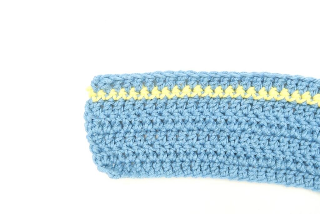 blanket section with yellow row of single crochet stitches