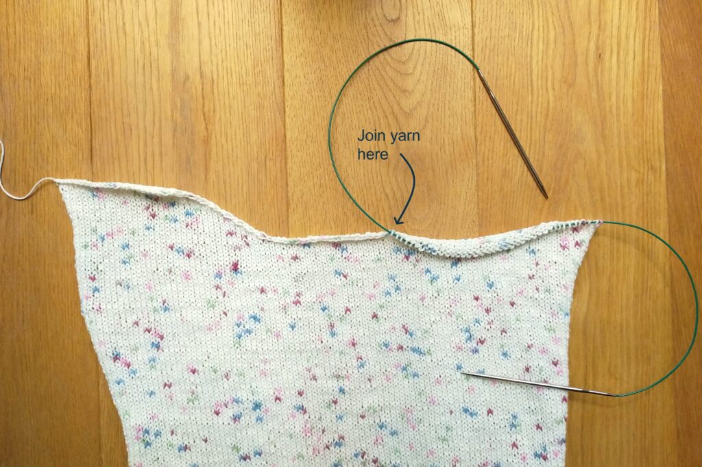 View of the knit top panel joining the yarn at the neckline