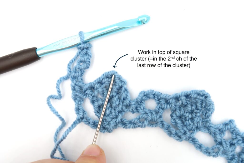 detailed view of where to insert your hook in the top of the crochet square cluster
