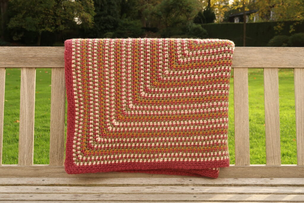 free  indian summer crochet blanket pattern folded on a bench