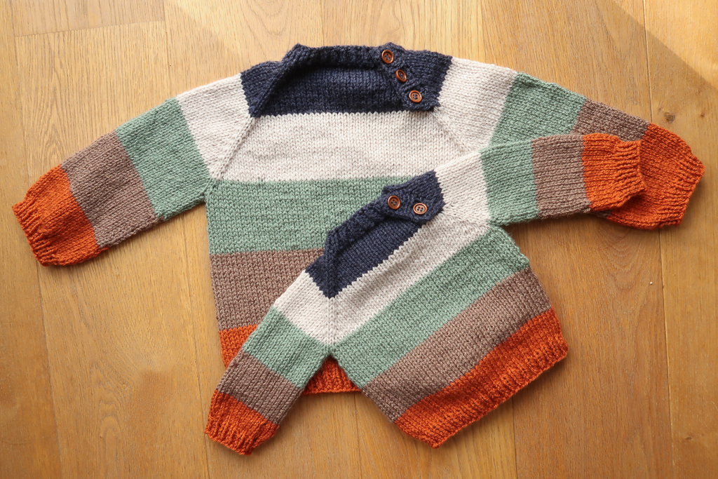 2 striped top down raglan sweater for children laid flat
