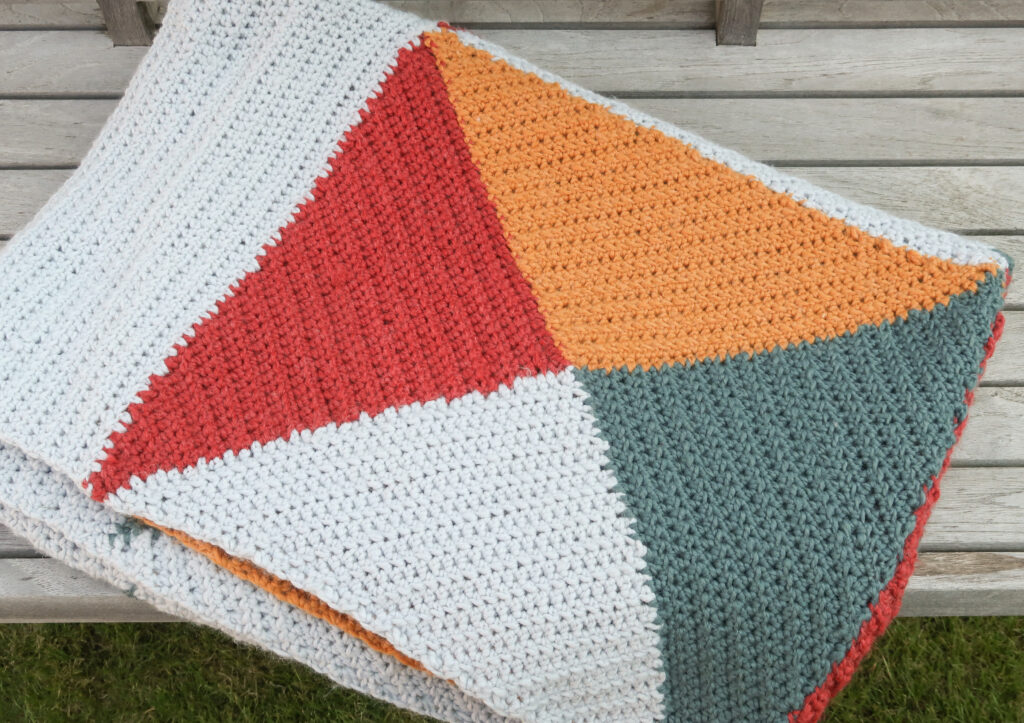 folded kaleidoscope blanket on a bench