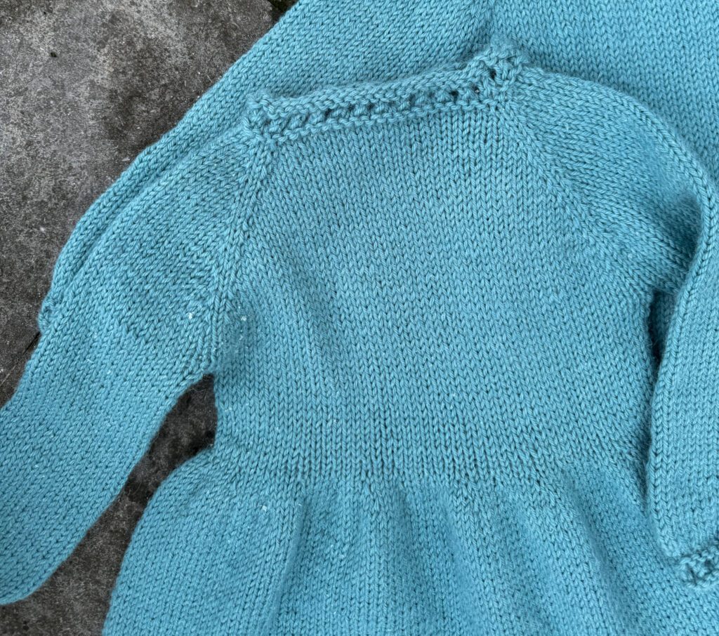close view of the top section of the baby dress knitting pattern free