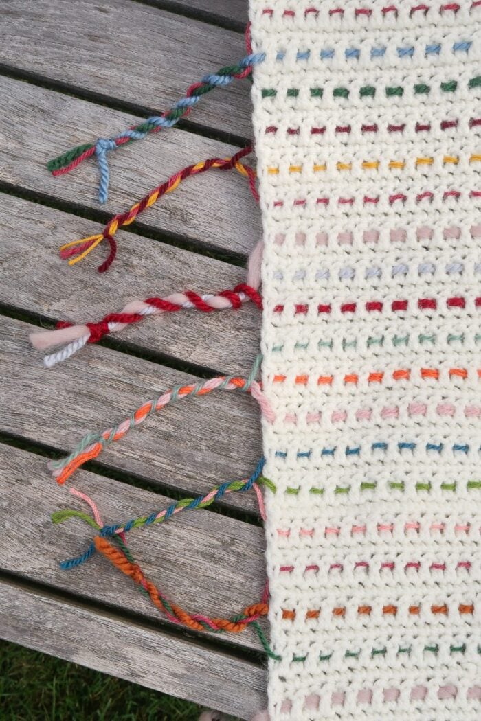 Twisted fringe edge on a scrapghan made from leftover yarn scraps