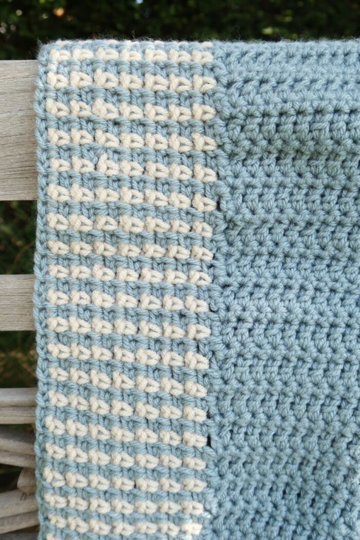 Close up of a two color crochet blanket edging on the corner