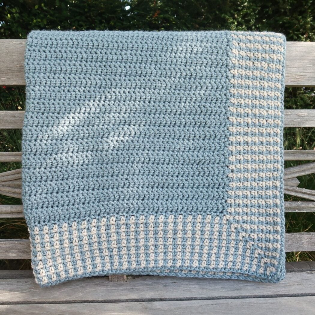 Moss stitch crochet blanket pattern draped diagonally to show the full design